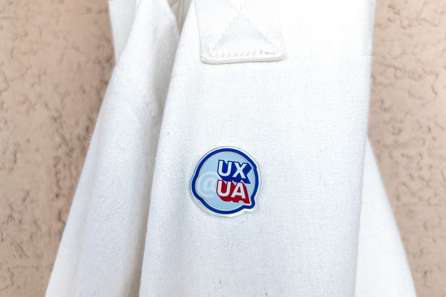 A white tote with a UX@UA pin